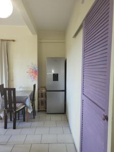 a kitchen with a table and a refrigerator at F2 Proches de toutes commodités in Ducos