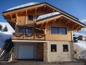a house with a balcony and a garage at Les flocons in Crest-Voland