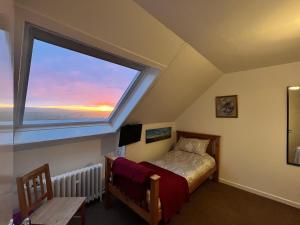 una camera da letto con un letto e una grande finestra di Fianais Cottage @ The Decca - Self Catering -Lewis a Lionel Altre 43 foto