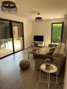 a living room with a couch and a table at Casa Juliette Maison bois in Aléria