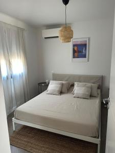 a bed with white sheets and pillows in a bedroom at Casa Juliette Maison bois in Aléria