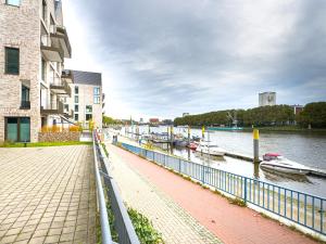a walkway next to a river with boats in it at ImmoStay M#Apartments Waterfront - WiFi & Parking in Bremen +56 photos