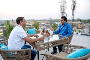 two men sitting at a table on a roof at Hotel Sun Grand in Agra