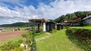 a small house with a thatched roof on a field at Ploy&Praew โดม 2 in Ban Sop Mae Klang