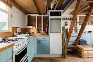 基督城Stargazing Beach Hut on Mudeford Sandbank with wake up sea views的厨房配有蓝色橱柜和白色冰箱