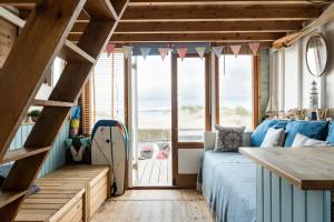 基督城Stargazing Beach Hut on Mudeford Sandbank with wake up sea views的一间带床和大窗户的卧室