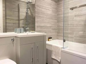 a bathroom with a sink and a shower and a tub at Modern & Stylish 2 Bedroom 2 Bath Apartments in Rochester in Rochester +136 photos
