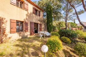 una casa con tavolo e sedie nel cortile di Ajoucadou - Vue sur le Cap Lardier a La Croix-Valmer