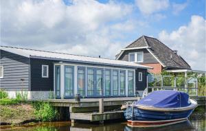 ein Haus mit einem Boot, das auf einem Dock geparkt ist in der Unterkunft Bodelaeke-Rietwoning in Giethoorn