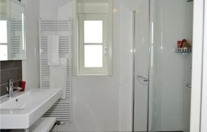 ein weißes Badezimmer mit Waschbecken und Dusche in der Unterkunft Bodelaeke-Rietwoning in Giethoorn