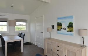 ein Esszimmer mit einem Tisch und einem Schreibtisch mit Stühlen in der Unterkunft Bodelaeke-Rietwoning in Giethoorn