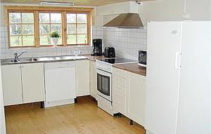 a kitchen with white cabinets and a white refrigerator at Stunning Home In Ljungby With Lake View in Bolmstad