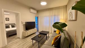 a living room with a couch and a tv and a bed at SeaBreeze City Center Flats by TrulyCyprus in Limassol +52 photos