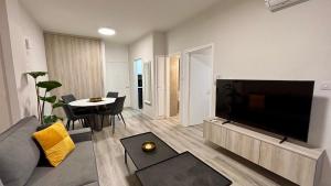 a living room with a large flat screen tv at SeaBreeze City Center Flats by TrulyCyprus in Limassol