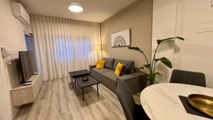 a living room with a couch and a television at SeaBreeze City Center Flats by TrulyCyprus in Limassol +38 photos