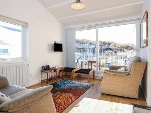 a living room with two chairs and a large window at The Moorings Apartment in Porthmadog