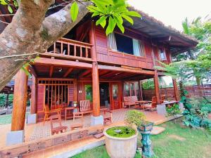 a wooden house with a porch and a patio at Moc Homestay & Villa in Cư Chinh