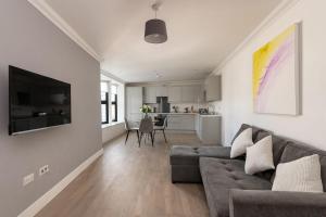 a living room with a couch and a kitchen at Modern & Stylish 2 Bedroom 2 Bath Apartments in Rochester in Rochester