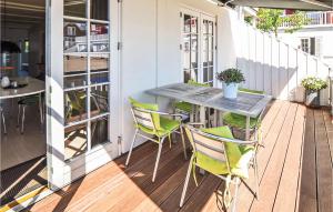 a patio with a table and chairs on a porch at Two-Bedroom Apartment In Grasten in Gråsten