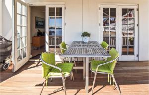 a table with green chairs on a patio at Two-Bedroom Apartment In Grasten in Gråsten