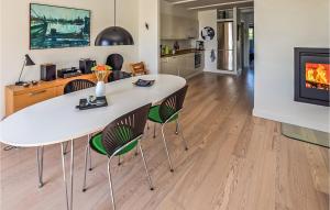 a kitchen and living room with a white table and chairs at Two-Bedroom Apartment In Grasten in Gråsten +8 photos