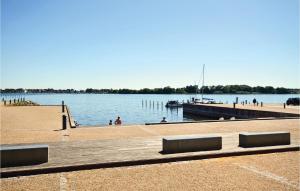 a dock with people swimming in the water at Two-Bedroom Apartment In Grasten in Gråsten
