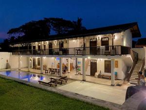 a large white house with a swimming pool at night at Ahangama Eco Villa in Ahangama