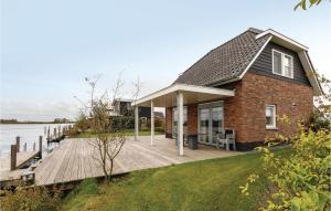 a house with a wooden deck next to the water at Bodelaeke-Rietburg Wellness 4P in Giethoorn