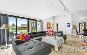un soggiorno con un divano e un tavolo di Holiday Home Kirkholm Strandby Kw Juelsminde X a Sønderby