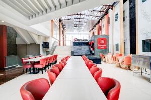 a long table with red chairs in a restaurant at Dancenter Promenade Near Cihampelas Walk in Bandung