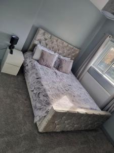 a large bed in a room with a window at 3 Bed Detached House & Hot Tub in Wrexham