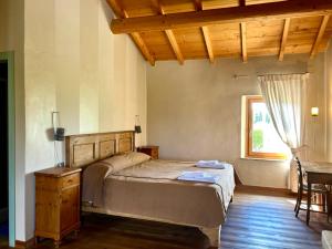 a bedroom with a bed and a table and a window at Cascina Girolda in Peschiera del Garda