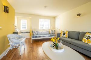 a living room with a couch and a table at 2 Bell Lodge, Thorpeness in Thorpeness