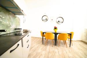 a kitchen with a black table and yellow chairs at The Place in Cutrofiano