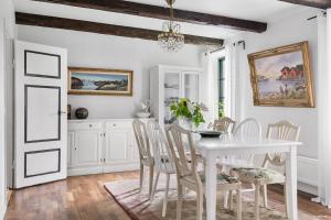 a white dining room with a white table and chairs at Klockargården Örja byväg 17 in Landskrona