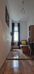 salon z drewnianą podłogą i kanapą w obiekcie Hostel Tulip - pokój nr 8 ze wspólną łazienką i kuchnią w Szczecinie