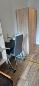 - biurko z krzesłem w pokoju z drewnianą podłogą w obiekcie Hostel Tulip - pokój nr 8 ze wspólną łazienką i kuchnią w Szczecinie