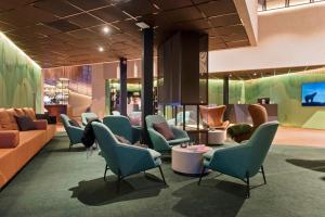 a waiting room with blue chairs and a couch at Radisson Blu Polar Hotel, Spitsbergen in Longyearbyen
