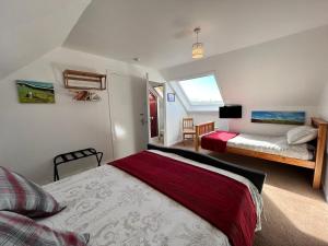 una camera da letto con due letti e una televisione di Fianais Cottage @ The Decca - Self Catering -Lewis a Lionel