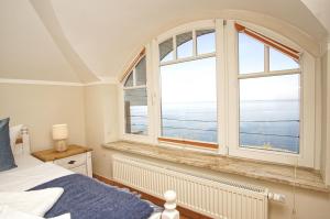 a bedroom with a large window with a view of the ocean at Ferienwohnung mit traumhaftem Meerblick - Haus am Meer FeWo 10 in Lohme