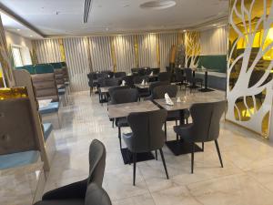 a restaurant with tables and chairs in a room at Orchid Hotel Deira in Dubai