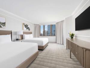 a hotel room with two beds and a flat screen tv at Fairmont Chicago Millennium Park in Chicago