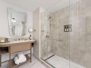 a bathroom with a shower with a sink and a mirror at Fairmont Chicago Millennium Park in Chicago