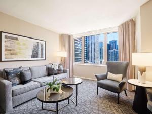 a living room with a couch and chairs and a large window at Fairmont Chicago Millennium Park in Chicago