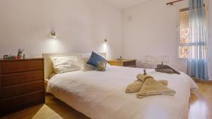 sypialnia z dużym białym łóżkiem z ręcznikami w obiekcie Private Terrace Home - Pool - Wifi w mieście Costa Calma