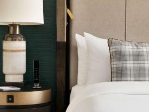 a bedroom with a bed with a lamp and a pillow at Fairmont Banff Springs in Banff