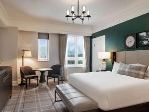 a hotel room with a bed and a table and chairs at Fairmont Banff Springs in Banff