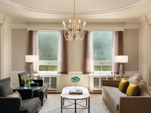 a living room with a couch and a chandelier at Fairmont Banff Springs in Banff