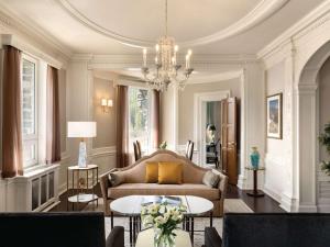 a living room with a couch and a chandelier at Fairmont Banff Springs in Banff