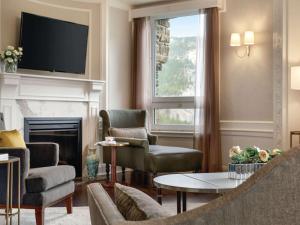 a living room with a fireplace and a tv at Fairmont Banff Springs in Banff